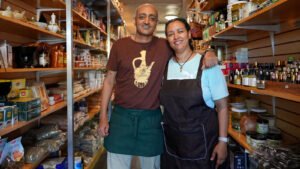 Owners of Buna Ethiopian Restaurant & Market standing is a food storage area.