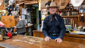 Owner of Country General Store wearing a cowboy hat, denim, amongst other western treasures.
