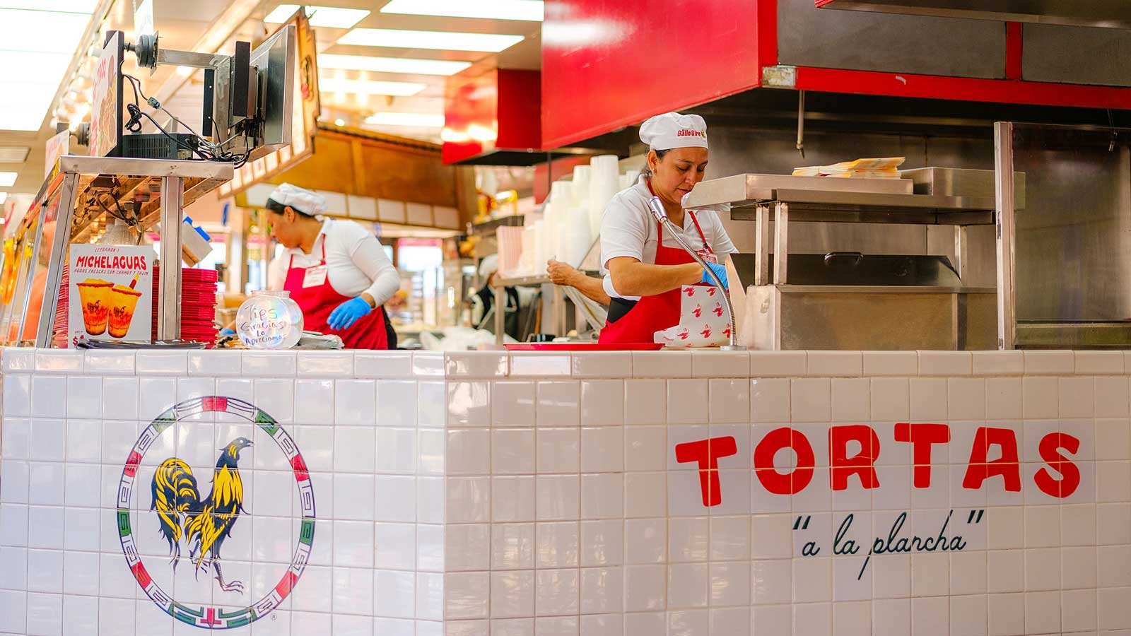 Two female chefs preparing food behind the counter