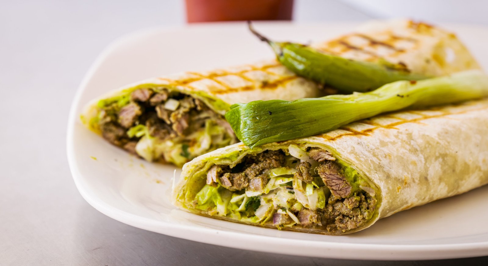 Don Shuco – two grilled wraps filled with steak and cheese, plated with a roasted green chile.