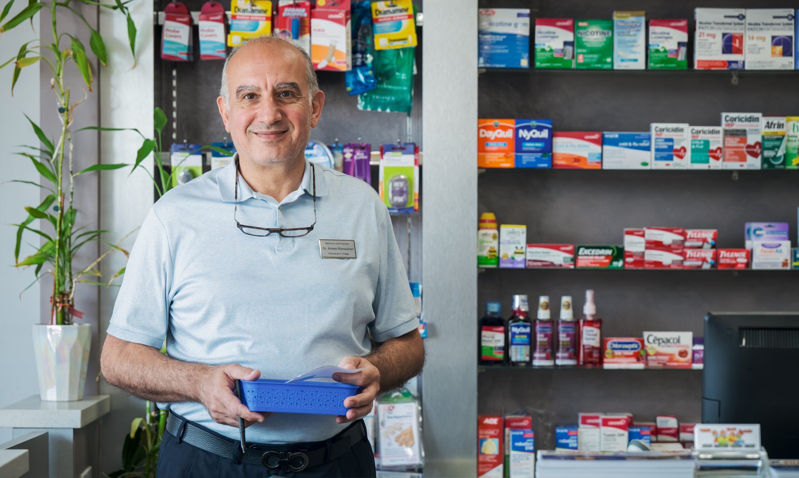 Medicine Land Pharmacy – pharmacist standing in front of shelves stocked with over-the-counter medicines.