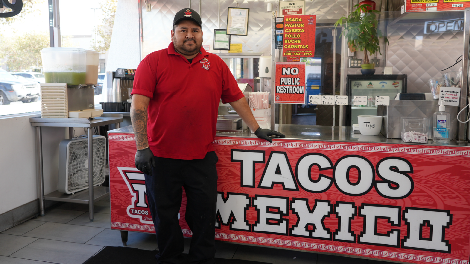Tacos Mexico – taquero standing at the service counter behind a red Tacos Mexico banner.