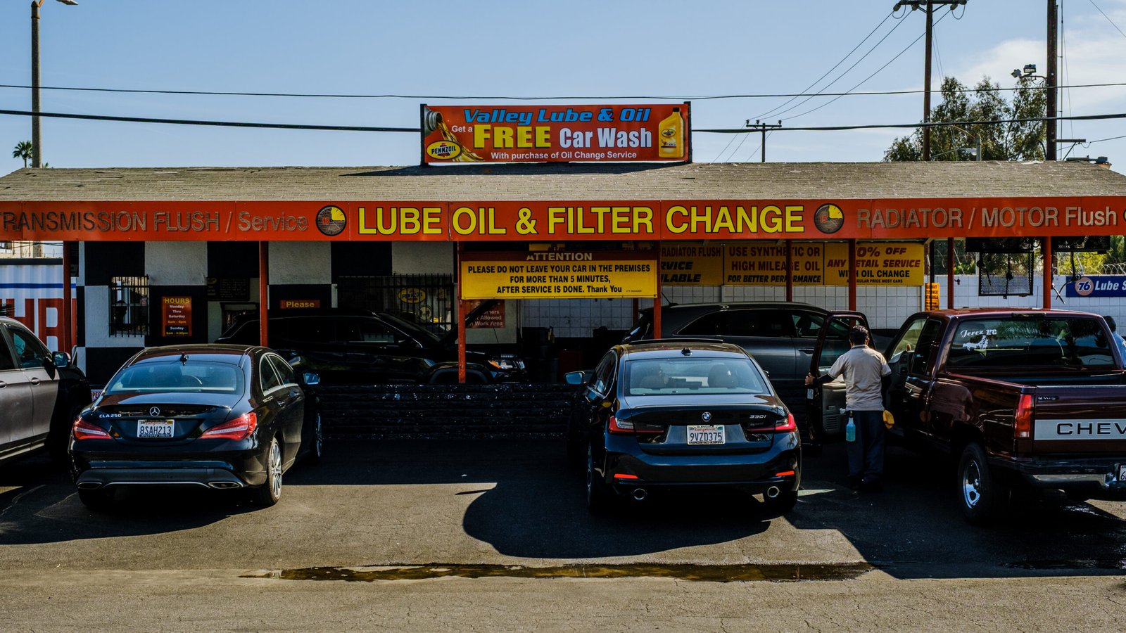 Valley Lube & Oil – cars parked in front of the shop's signs advertising lube, oil and filter change and a free car wash.